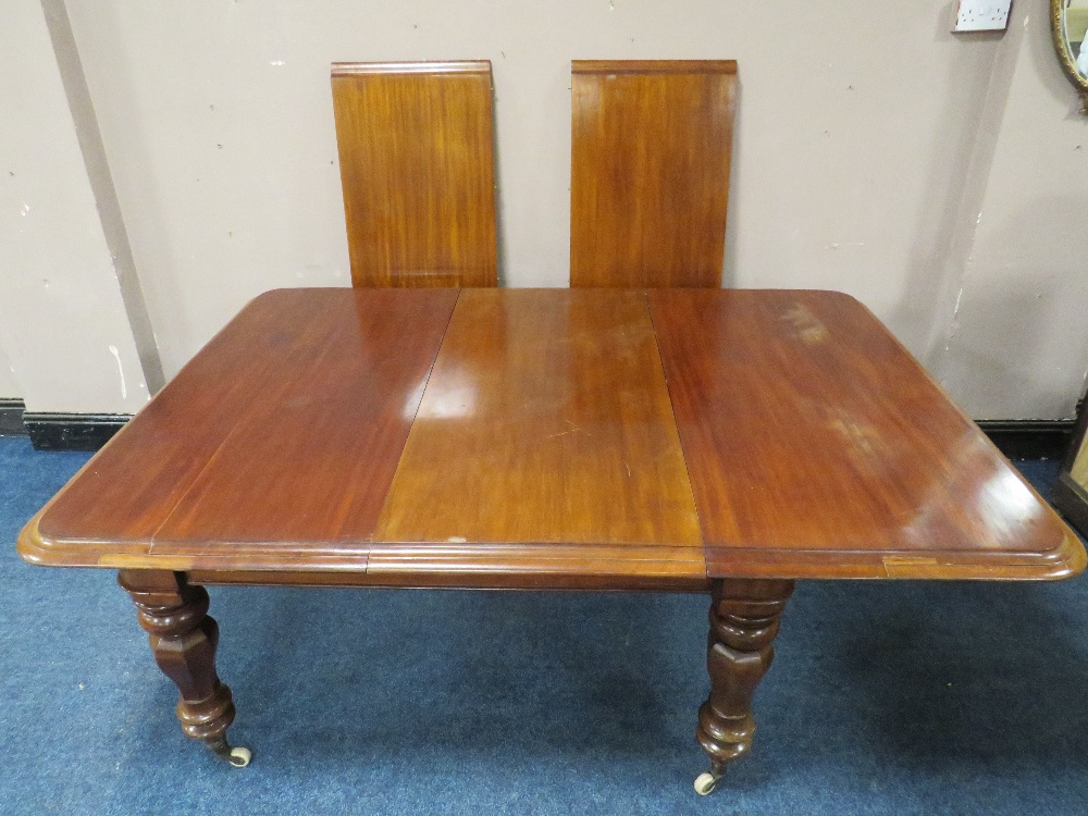 A 19TH CENTURY MAHOGANY PULL-OUT EXTENDING DINING TABLE WITH THREE ADDITIONAL LEAVES, raised on