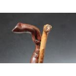 TWO FOLK ART WALKING STICKS, one carved in the style of a boxer dog head, L 85 cm