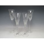 TWO STUART CRYSTAL STRATA PATTERN CHAMPAGNE FLUTES DESIGNED BY JASPER CONRAN, together with two