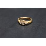 A UNUSUAL HALLMARKED 18 CARAT GOLD DIAMOND TRILOGY RING, set with graduating brilliant cut diamonds,