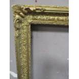 A 19TH CENTURY DECORATIVE GOLD FRAME WITH CORNER EMBELLISHMENTS, with some restoration, frame W 9.5,