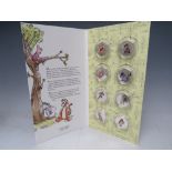 A WINNIE THE POOH LIMITED EDITION SILVER 50 PENCE SHAPED DECORATIVE COIN SET, number 171 of 499,
