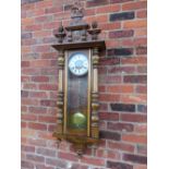 A LARGE GONG STRIKE VIENNA WALL CLOCK, the tall case comprising of oak pillars, mahogany veneered