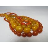 A COLLECTION OF AMBER AND LUCITE VINTAGE BEADS, comprising three necklaces and one braceletCondition