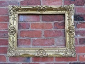A 19TH CENTURY DECORATIVE GOLD SWEPT FRAME, frame W 10 cm, rebate 54 x 36 cm