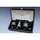 A CASED HALLMARKED SILVER THREE PIECE CRUET SET - BIRMINGHAM 1933, together with two salt spoons,