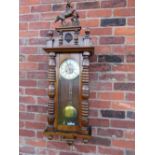 A KIENZLE GONG STRIKE VIENNA WALL CLOCK, the case having bold turned pillars, mahogany veneered