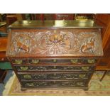 A 19TH CENTURY HEAVILY CARVED OAK BUREAU WITH FITTED INTERIOR W-117 CM