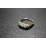 AN UNMARKED YELLOW METAL JADE RING STAMPED DIA