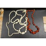 A VINTAGE MOTHER OF PEARL NECKLACE TOGETHER WITH A VINTAGE HAND KNOTTED AMBER TYPE / LUCITE BEAD