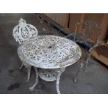 A CAST IRON GARDEN TABLE AND CHAIR WITH A MATCHED EXTRA CHAIR