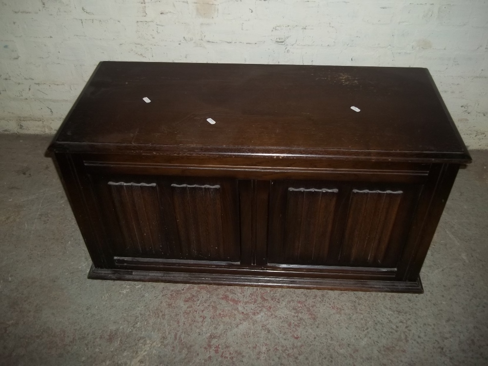 AN OAK BLANKET CHEST WITH LINEN FOLD DETAILING