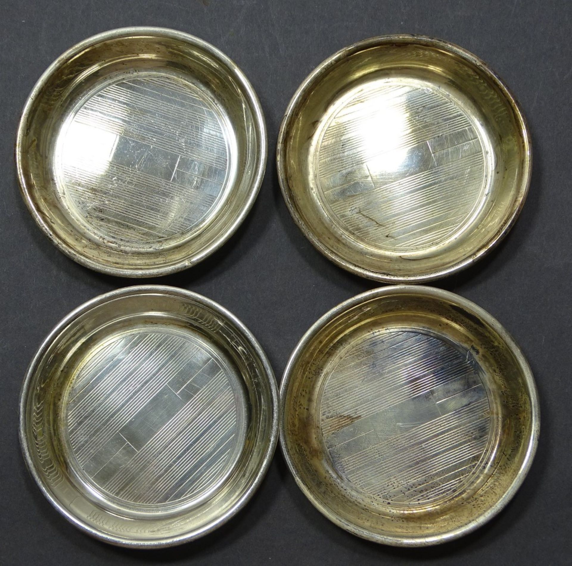 4 Silberuntersetzer oder Ähnliches, Sterling, 6,5 cm, H. 1 cm, zus. 53 gr., kleine Kratzer, reinign