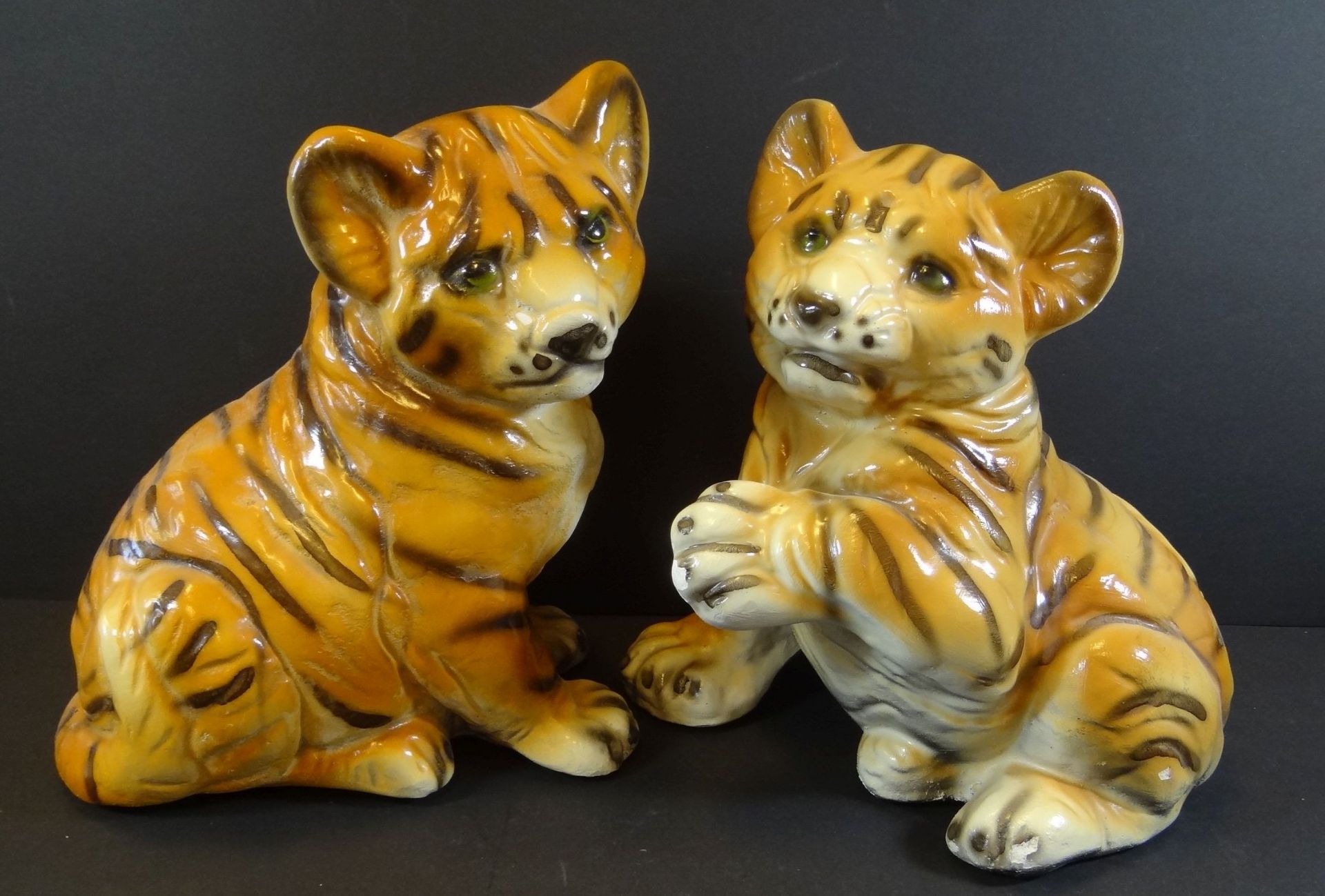 2x Tiger-Junge, bemalt, wohl Gips, 1x mehrfach beschädigt, H-23 cm