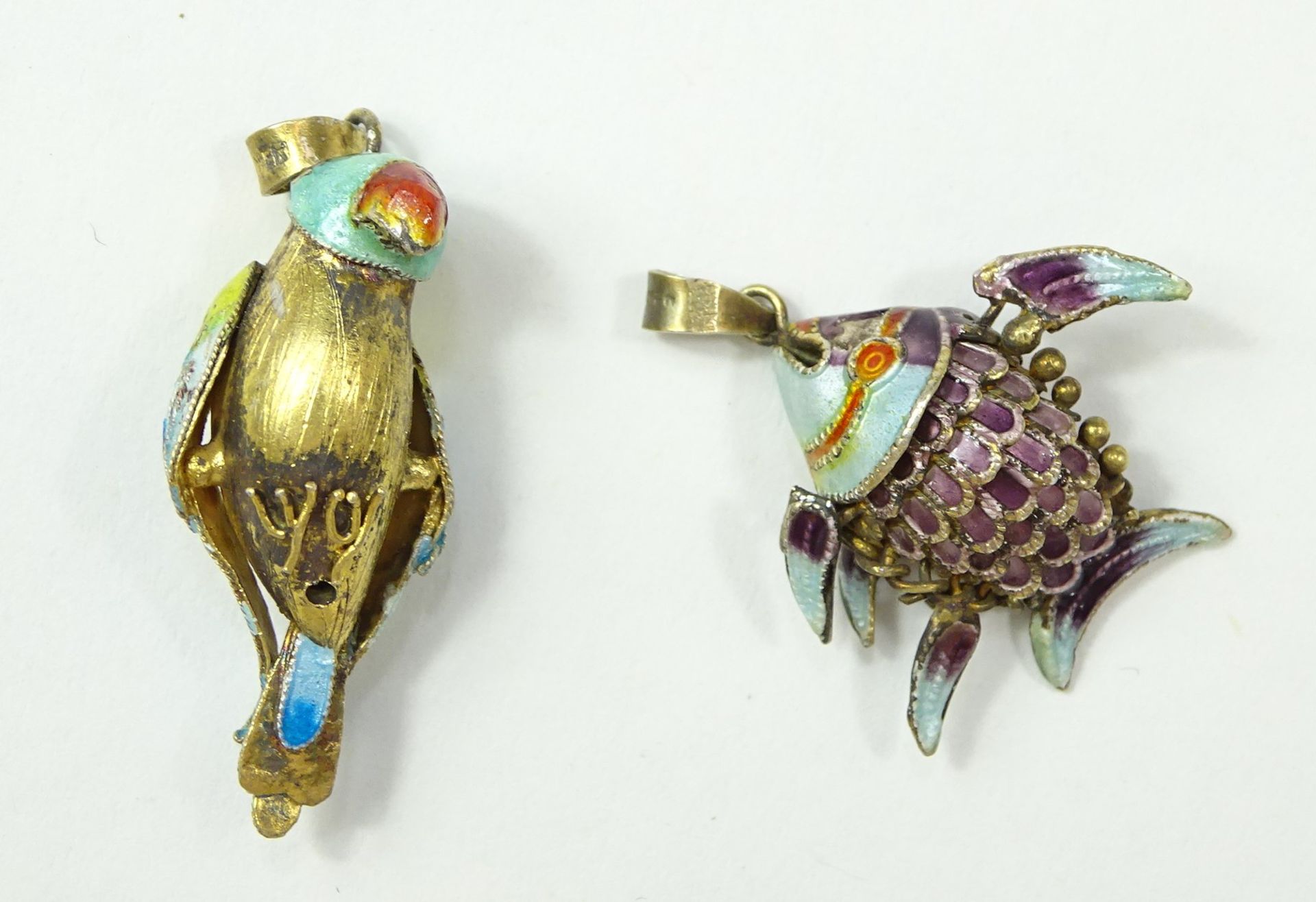 2 emaillierte Silberanhänger, Fisch und Papagei, L. 3 und 3,5 cm, zus. 5 gr., mit Altersspuren, rei