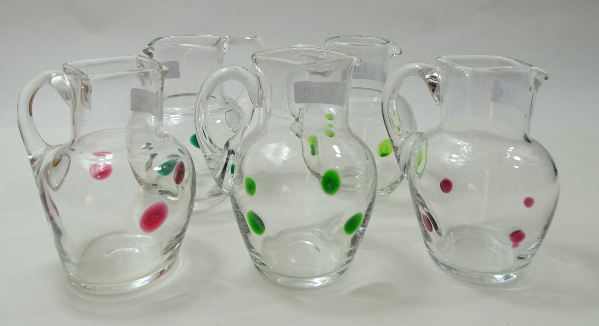 5 Kännchen, klares Glas mit aufgesetzten grünen und roten Punkten, H. 11,5 cm, 3 x eckiger, 1 x run