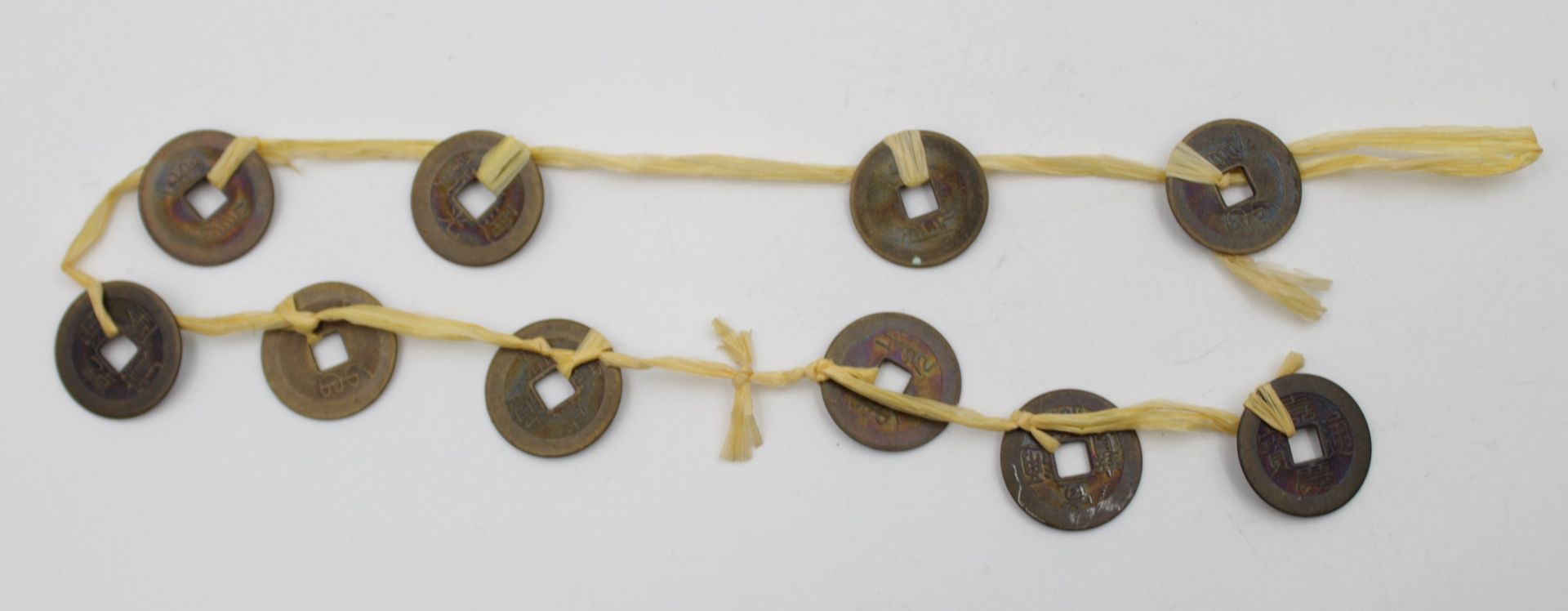 10x div. Münzen, China, alter?, an Band, ca. L-51cm.