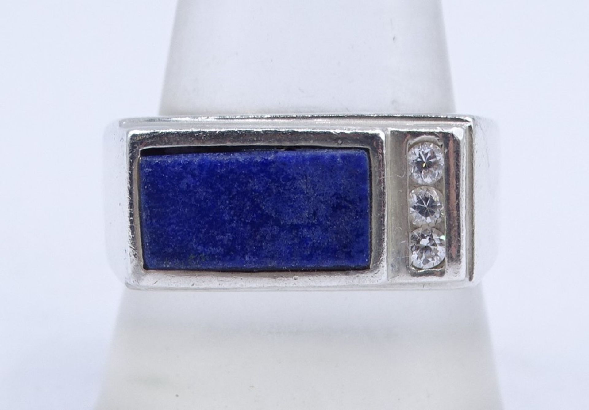 Silberring, 925/000, mit blauem und 3 klaren fac. Steinen, Kopf: 1 x 2 cm, RG 64, 8,38 gr., mit Tra