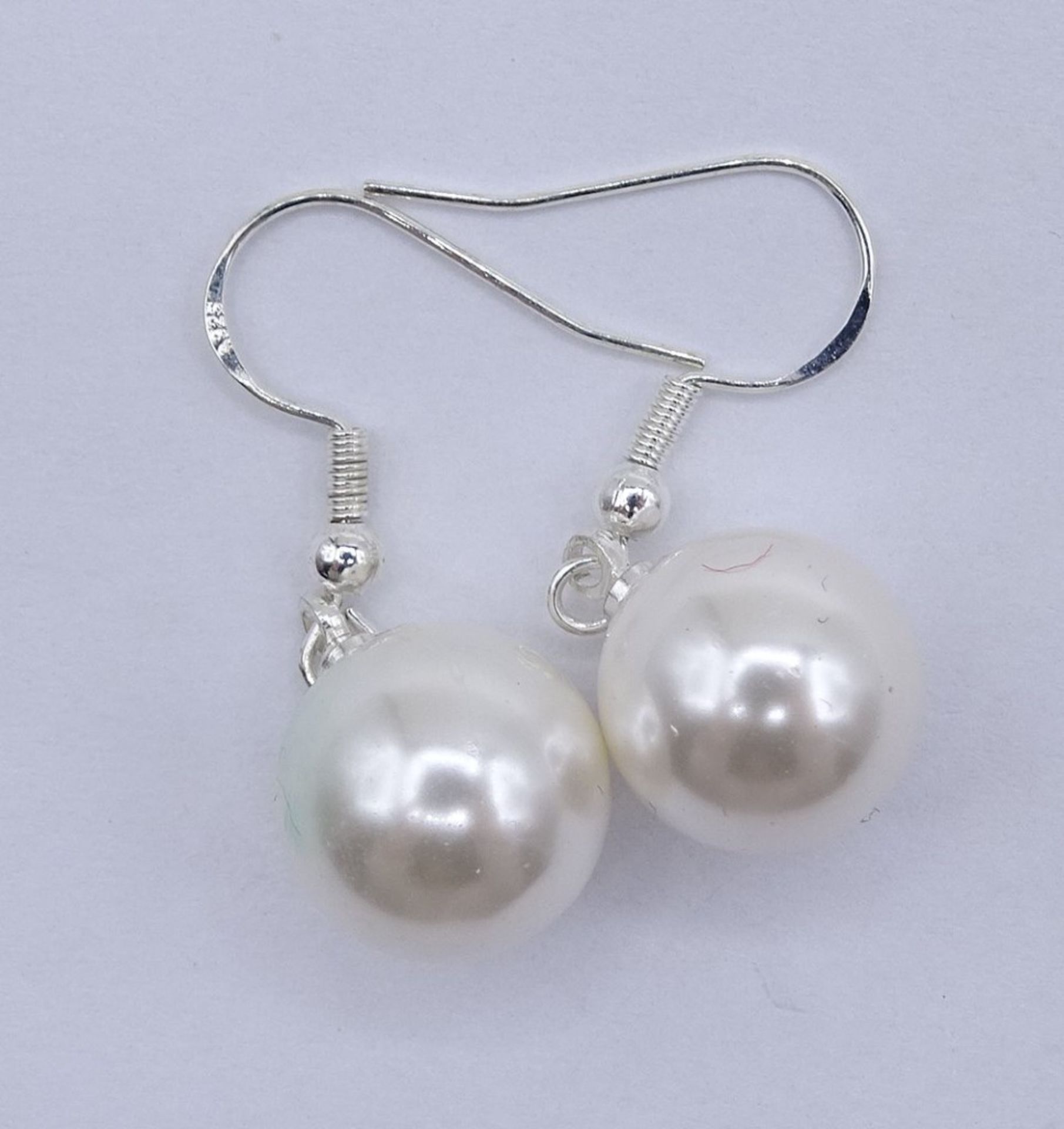 Perlenohrhänger, 925er-Silbermontur, Ø Perlen: 1,1 cm, L. 3,5 cm, 5 gr., eine Perle mit Kratzer