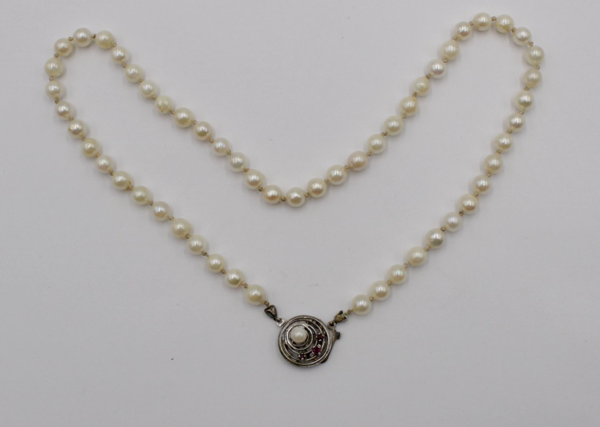 Perlenkette, 835er Silberschließe, besetzt mit kl. Rubinen, ca. L-45cm.