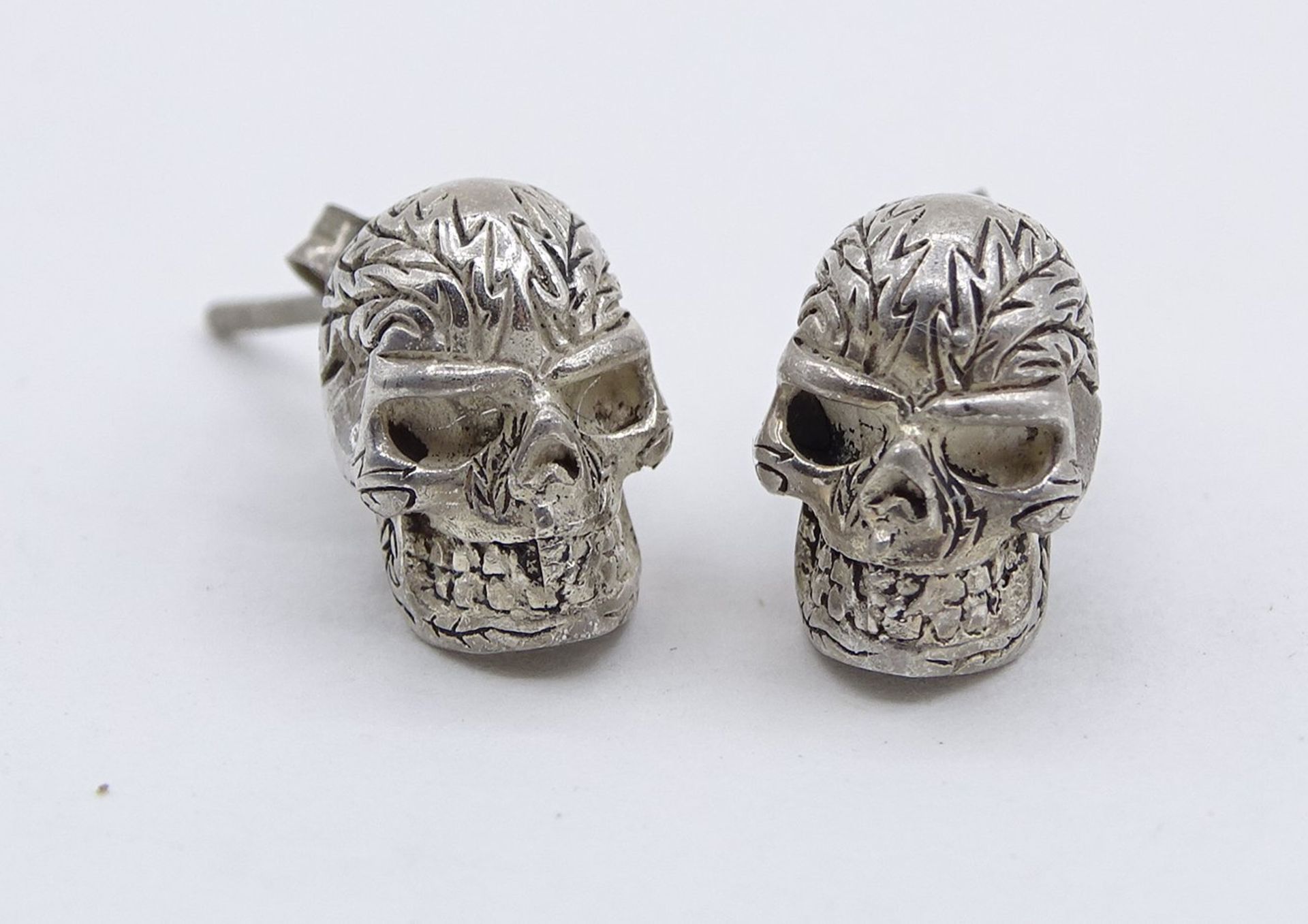 Ohrstecker in Totenkopfform, 925er-Silber, 0,7 x 1 cm, zus. 3 gr., mit Altersspuren, reinigungsbedü