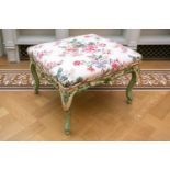 A green and floral painted George I style foot stool with chintz stuff over upholstery and shell