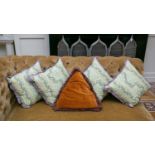 A set of four decorative square scatter cushions, together with a triangular velour scatter cushion.