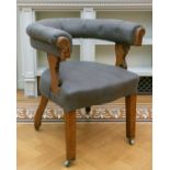 A late Victorian oak 'horseshoe' backed tub chair with stuff over upholstery on square tapering
