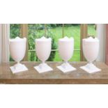 A set of four white painted composition Hollywood Regency style urns of two handled form on