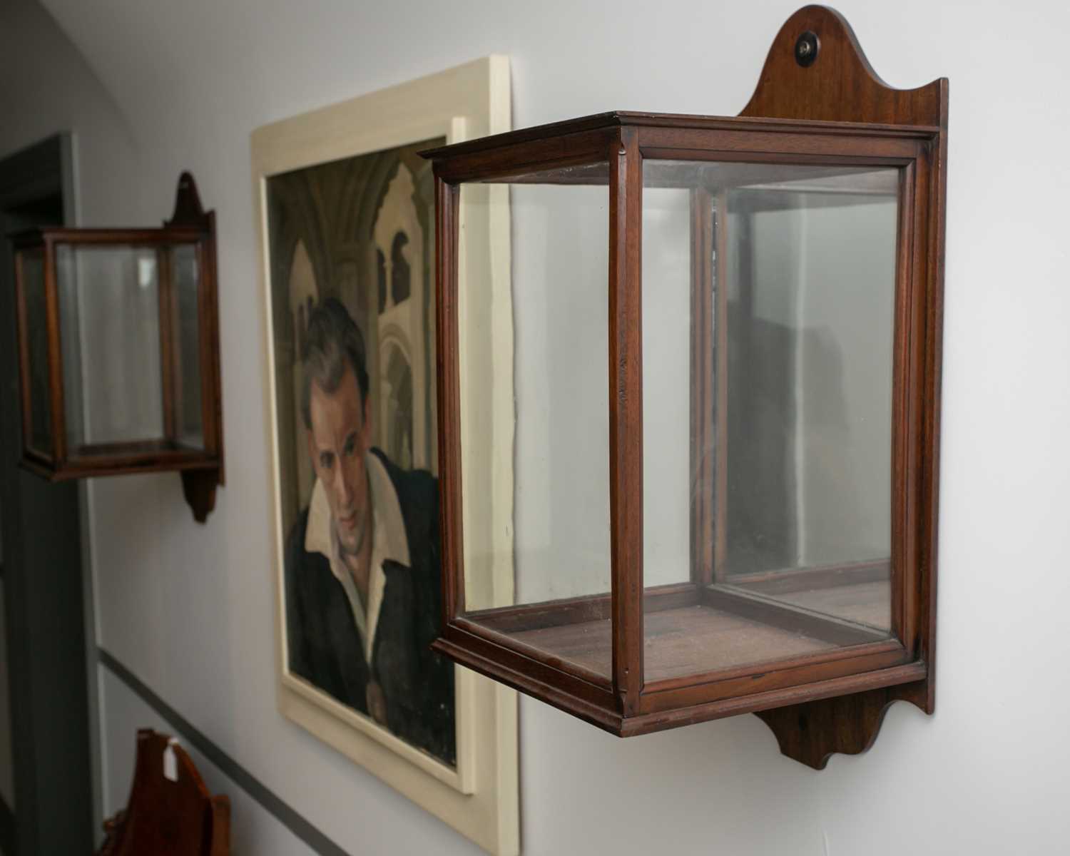 A pair of late Victorian mahogany glazed storm lamp holders or wall lanterns, with shaped