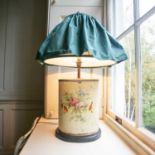 A decorative 20th century toleware lamp of oval section painted with cut blooms with ruffled green