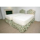 A pair of floral chintz upholstered serpentine topped single headboards, together with matching