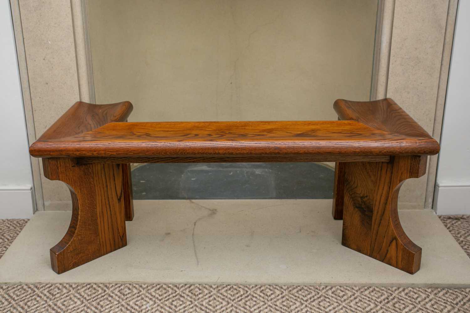 A 20th century stained oak club fender with moulded seat and architectural supports. Aperture: 59cm.