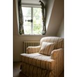 An Edwardian style scroll back easy chair with stuff over upholstery, with loose saving covers and