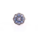 A sapphire and diamond cluster ring, set with a central rose cut sapphire surrounded by eight oval