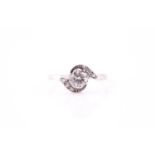 An Edwardian diamond crossover ring, the eight claw set round brilliant cut diamond with three