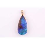 A large pear shape black opal, measuring 28x13.7mm approx, claw set into yellow metal pendant with