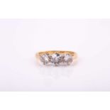 An 18ct yellow gold three stone diamond ring, set with a central 5.4mm round old mine cut diamond