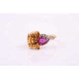 An 18 carat yellow and white gold ruby and diamond ring, the pear shaped ruby set with eight-cut