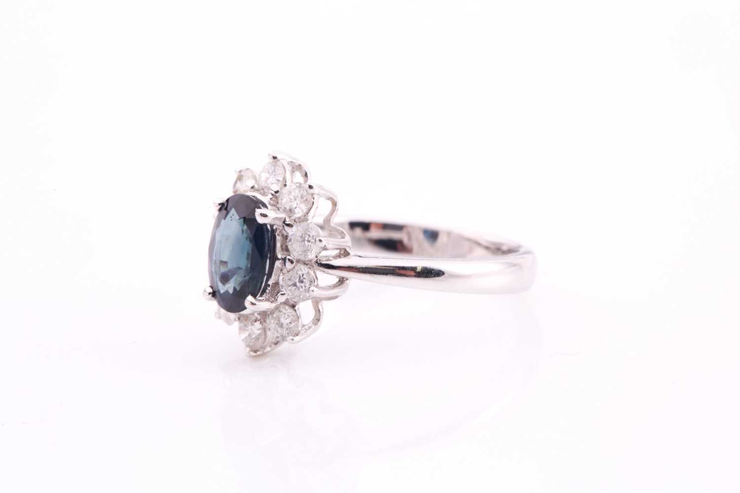 A sapphire and diamond cluster ring, set with an oval sapphire measuring 7.1mm x 5.6mm with a weight - Image 4 of 4