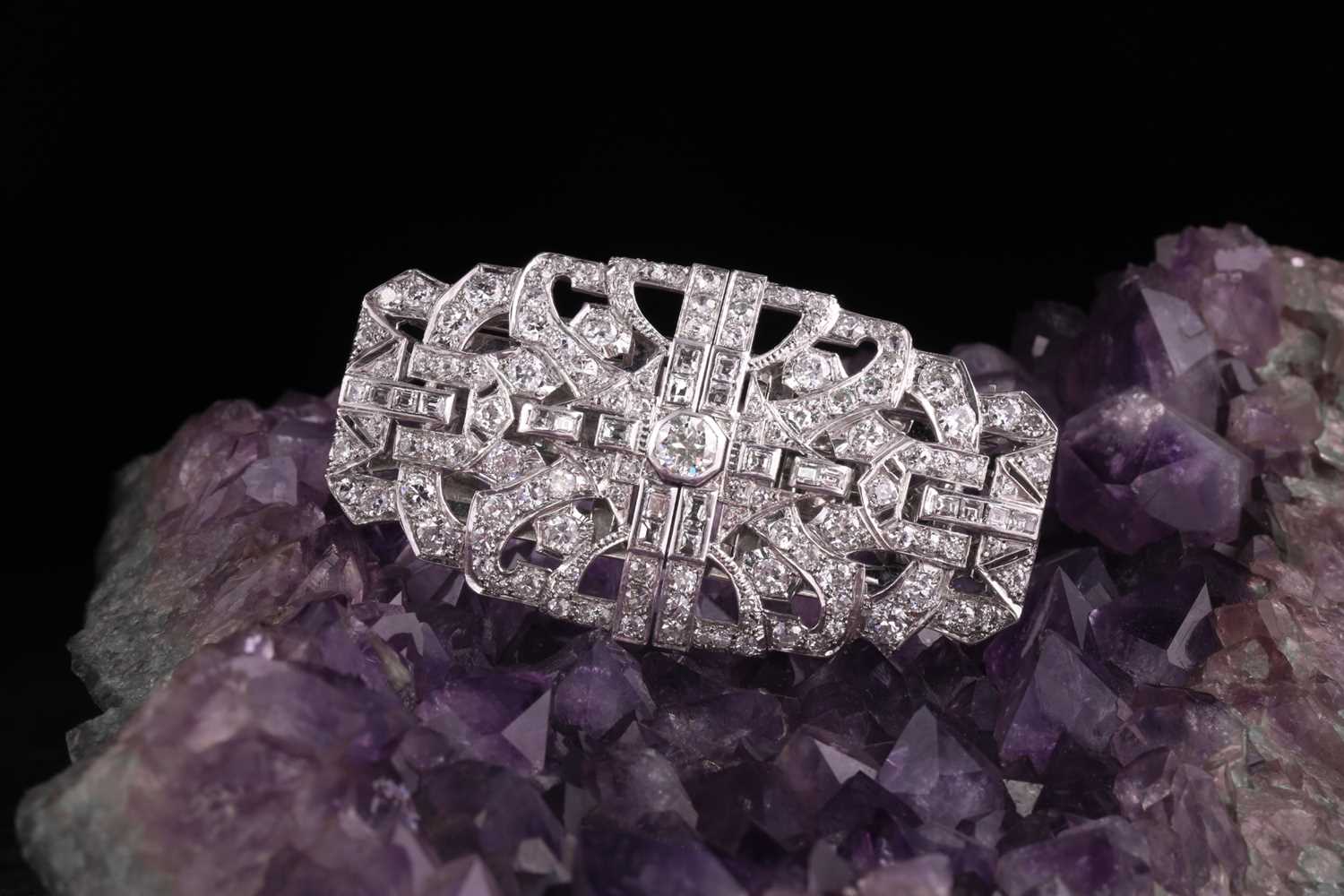 An Art Deco diamond lapel brooch, the large rectangular openwork mount centred by a collet set round