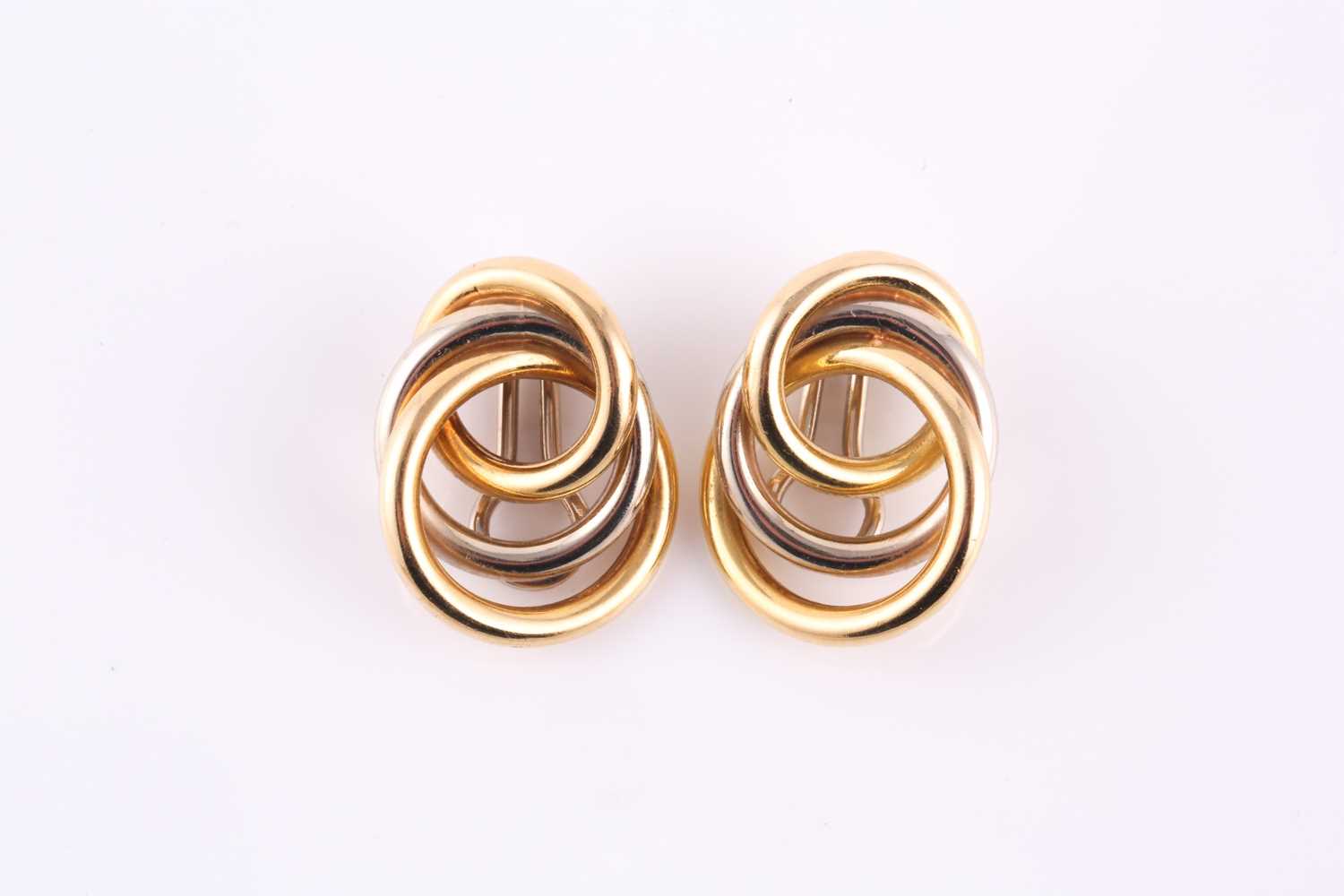 A pair of solid knot earrings, made from yellow and white metal loops stamped 'Italy K18' with