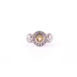 A diamond and yellow sapphire three stone ring, the central yellow sapphire collet set within a