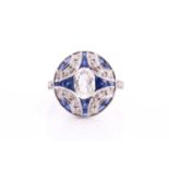 An art deco style calibrated sapphire and diamond dress ring, set with a central oval diamond