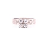 A four stone diamond ring, the round brilliant cut diamonds claw set to a square high mount,