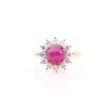 A Burmese ruby and diamond cluster ring set with a cabochon Burmese ruby of an estimated weight of