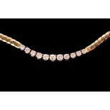 A flat snake chain necklace set with eleven graduated brilliant-cut diamonds in white metal, with