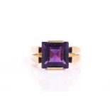 A square amethyst dress ring, set with a square step-cut amethyst on a raised split shank mount on