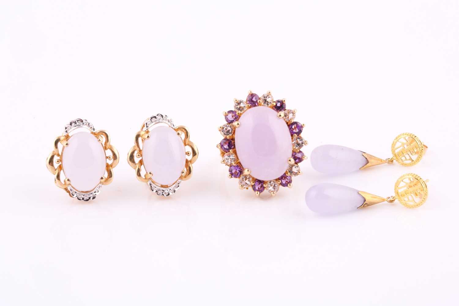 Lavendar colour jade cabochon ring, within a purple and white paste set surround, yellow precious
