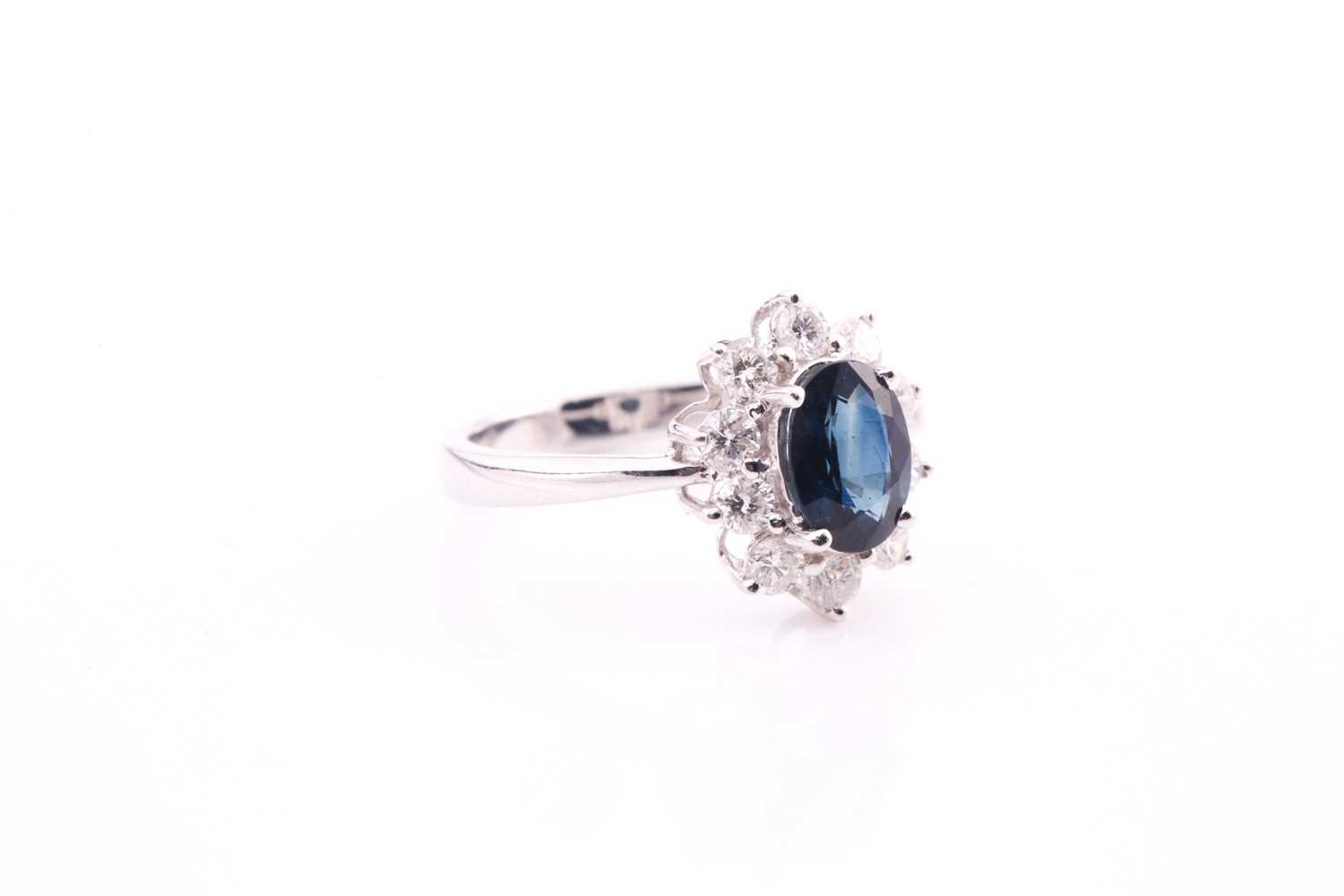 A sapphire and diamond cluster ring, set with an oval sapphire measuring 7.1mm x 5.6mm with a weight - Image 3 of 4